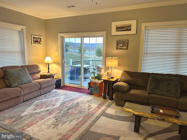 living room featuring carpet floors, ornamental molding, and visible vents