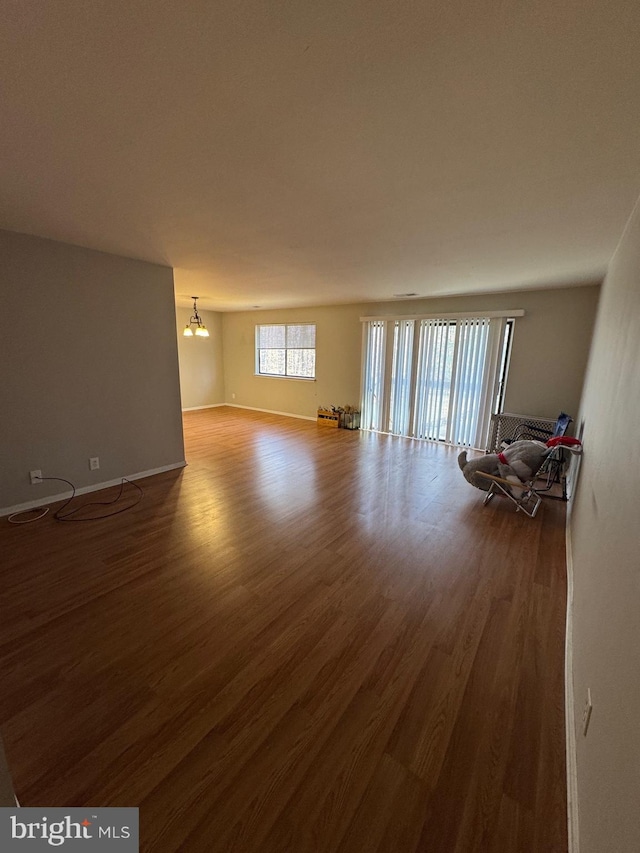 unfurnished room with wood-type flooring and a notable chandelier