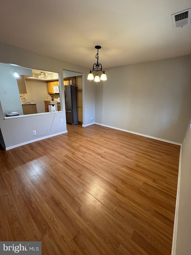 interior space featuring hardwood / wood-style floors, sink, and an inviting chandelier