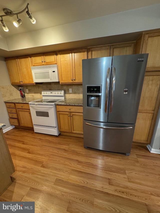 kitchen with light stone countertops, white appliances, tasteful backsplash, and light hardwood / wood-style flooring