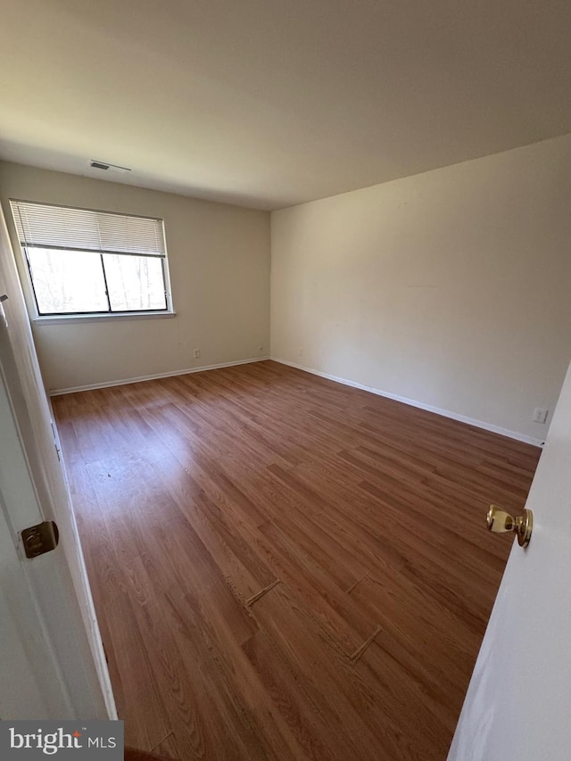 unfurnished room with wood-type flooring