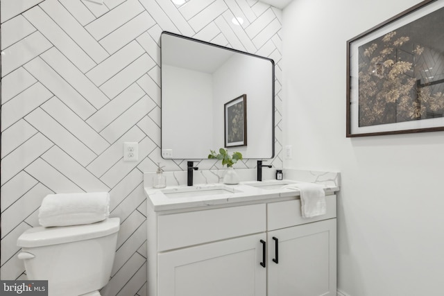 bathroom with toilet, vanity, and tile walls