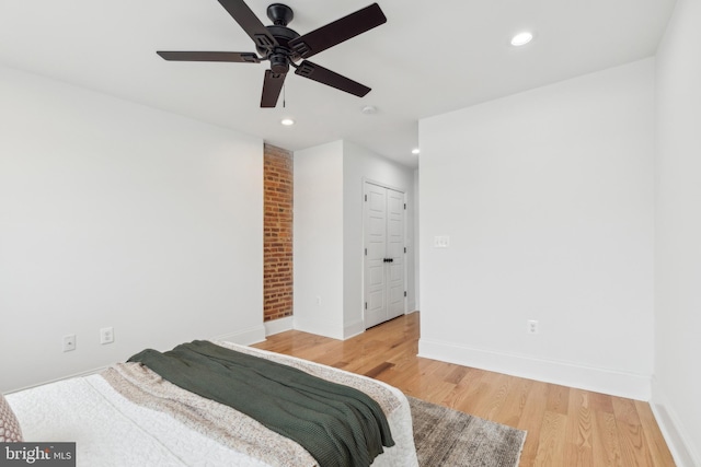 bedroom with ceiling fan, wood-type flooring, and a closet