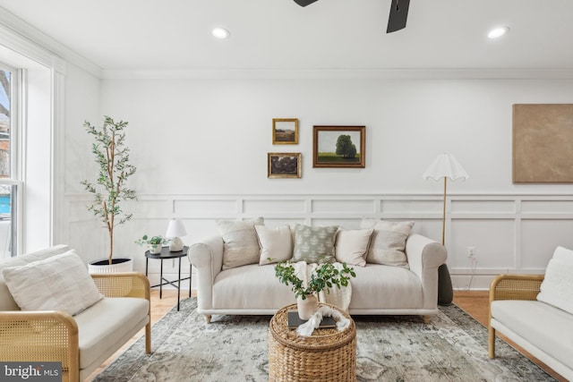 living room with ceiling fan, crown molding, and light hardwood / wood-style flooring