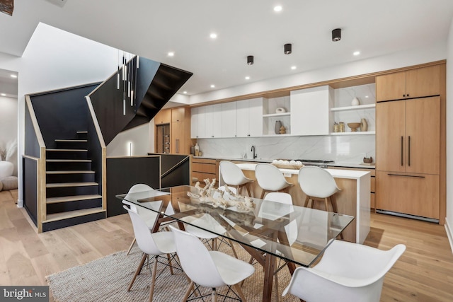 dining space featuring light wood-type flooring and sink