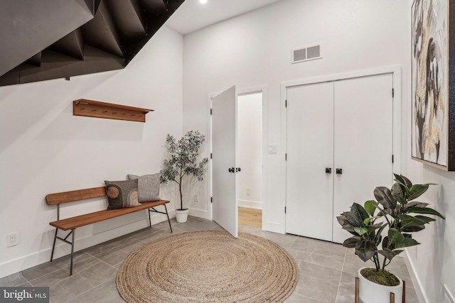 foyer with tile patterned floors and a towering ceiling