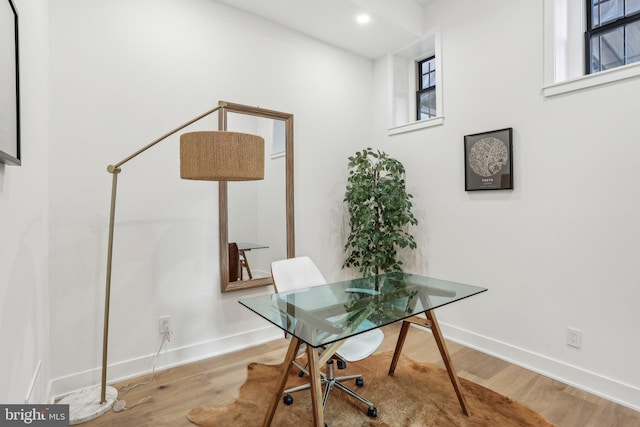 home office with a wealth of natural light and hardwood / wood-style flooring