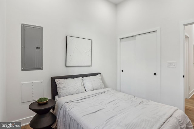 bedroom featuring a closet, hardwood / wood-style flooring, and electric panel