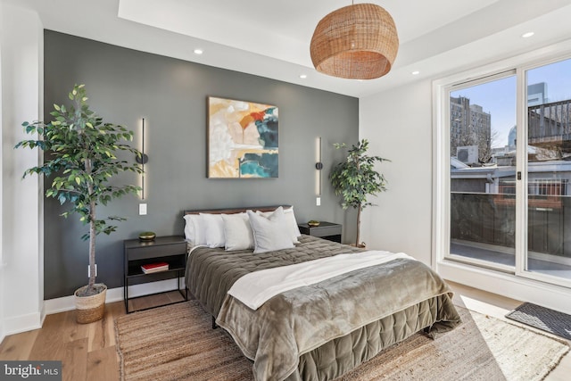 bedroom featuring a raised ceiling and hardwood / wood-style floors