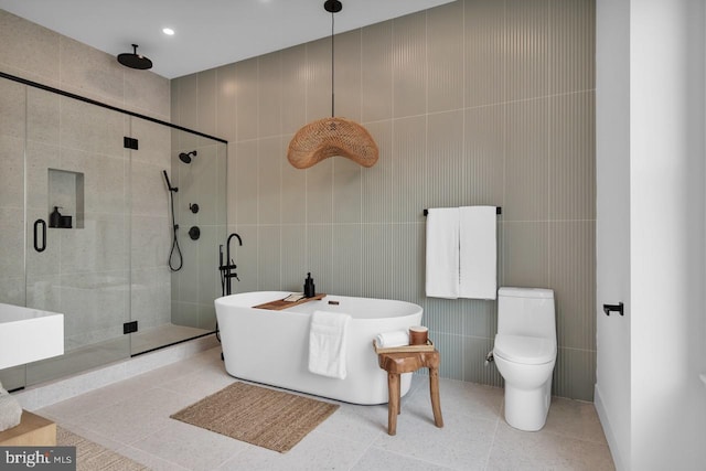 bathroom featuring tile patterned flooring, tile walls, toilet, and shower with separate bathtub