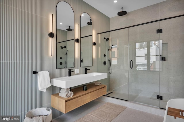 bathroom featuring sink, tile walls, walk in shower, and tile patterned flooring