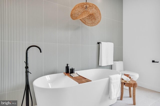 bathroom with a tub and tile walls