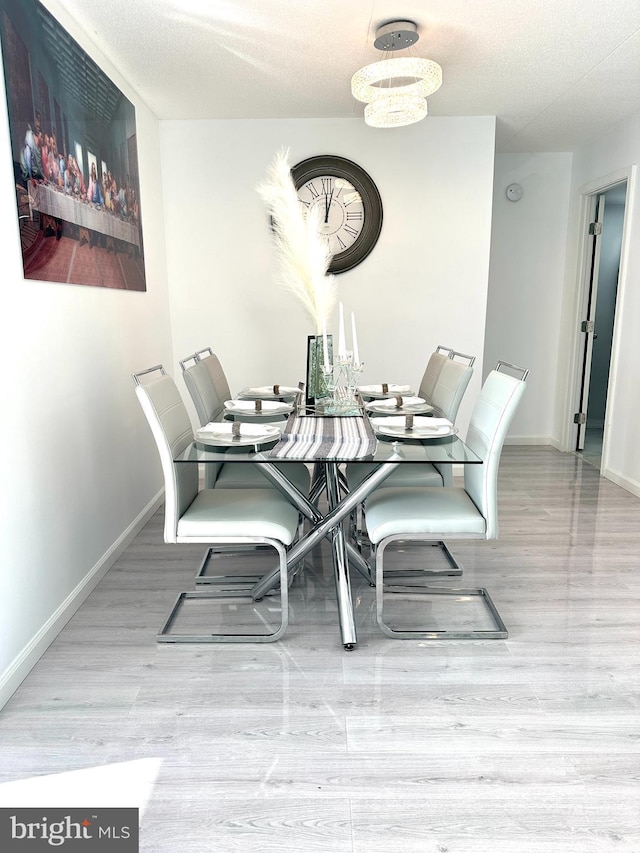 dining area with a chandelier and light hardwood / wood-style flooring