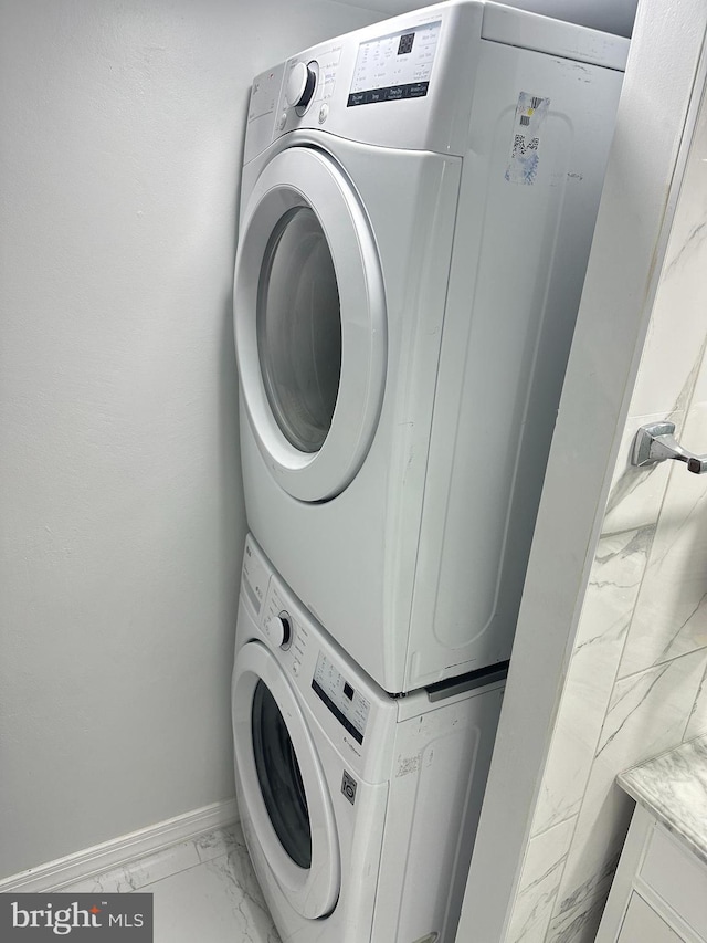 clothes washing area featuring stacked washer and dryer