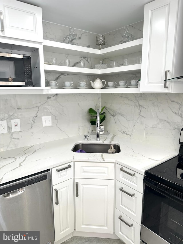 kitchen with sink, white cabinets, tasteful backsplash, and appliances with stainless steel finishes