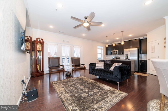 living room featuring dark wood-type flooring, ceiling fan, and ornamental molding