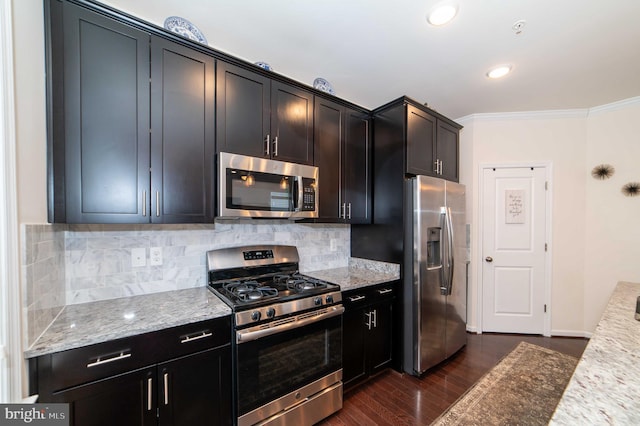 kitchen with backsplash, dark hardwood / wood-style flooring, ornamental molding, light stone counters, and stainless steel appliances