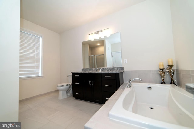 bathroom featuring tile patterned floors, toilet, vanity, and tiled tub