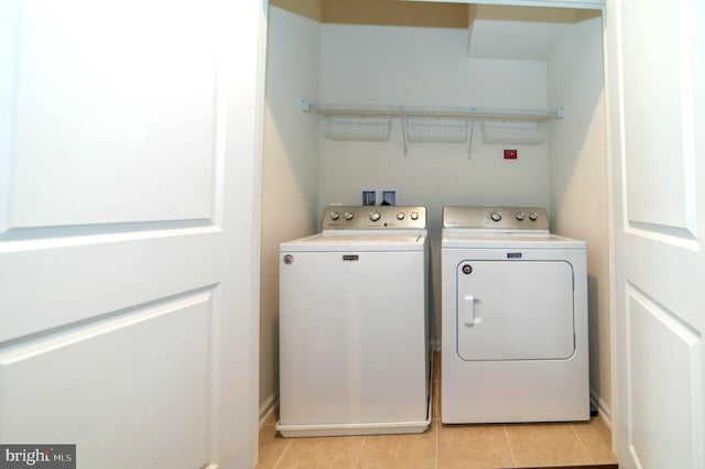 clothes washing area with light tile patterned floors and washing machine and clothes dryer