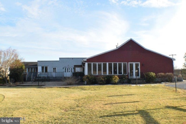 back of property featuring a lawn