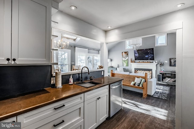 kitchen featuring an inviting chandelier, dark hardwood / wood-style floors, dishwasher, white cabinets, and sink