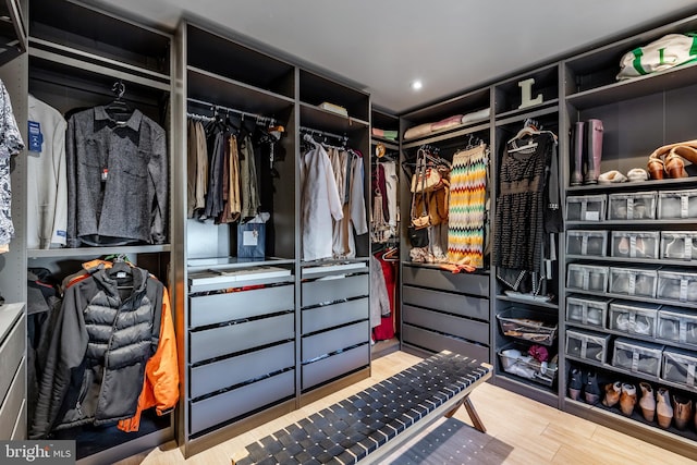 walk in closet with light hardwood / wood-style floors