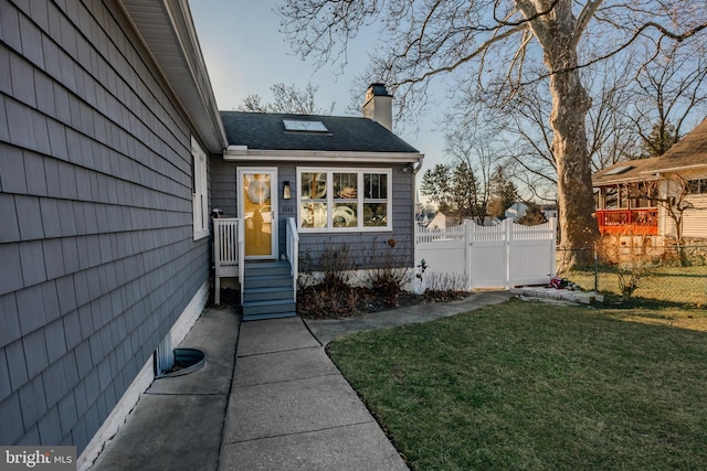 property entrance featuring a lawn