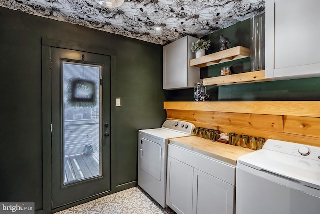 washroom with light tile patterned floors, cabinets, and washer and clothes dryer