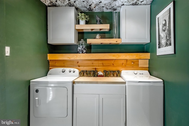 laundry area featuring washing machine and clothes dryer and cabinets