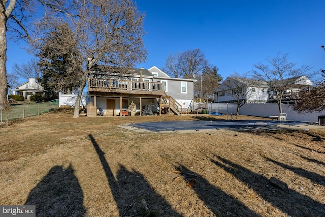 rear view of property featuring a lawn, a patio, and a wooden deck