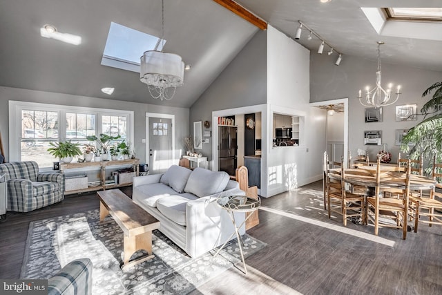 living room featuring dark hardwood / wood-style floors, a skylight, high vaulted ceiling, and a notable chandelier