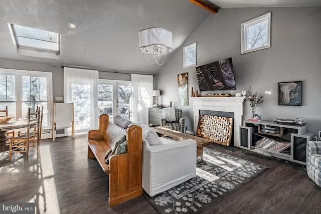 living room with beam ceiling, a skylight, a notable chandelier, and dark hardwood / wood-style floors