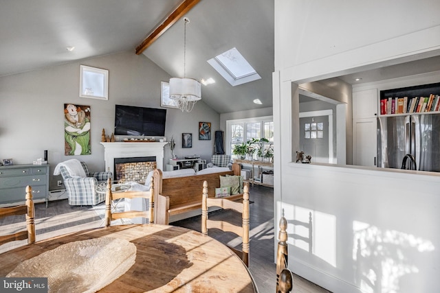 dining area featuring wood-type flooring, lofted ceiling with skylight, and a notable chandelier