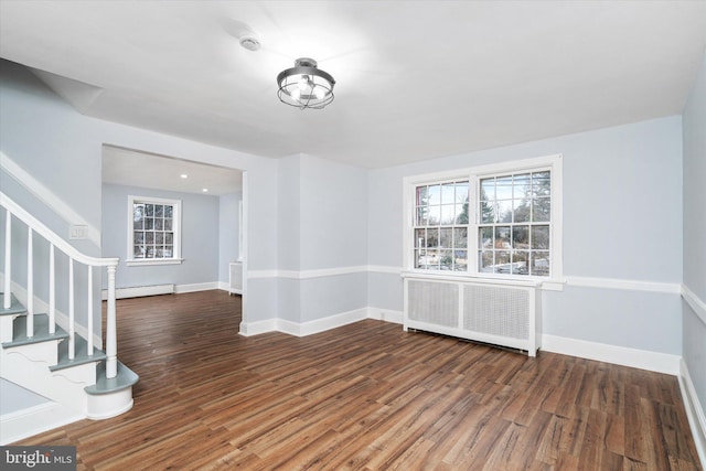 spare room with radiator heating unit, dark hardwood / wood-style floors, and a baseboard heating unit