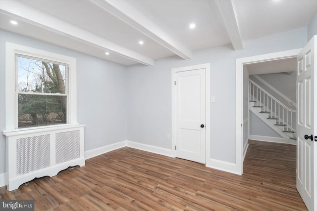 spare room featuring beamed ceiling, dark hardwood / wood-style flooring, and radiator