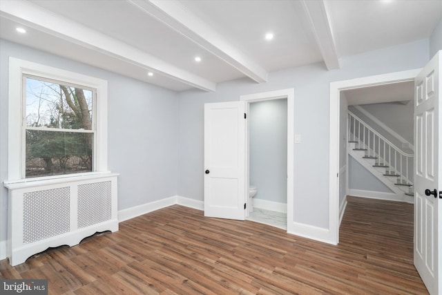 basement with radiator and dark wood-type flooring