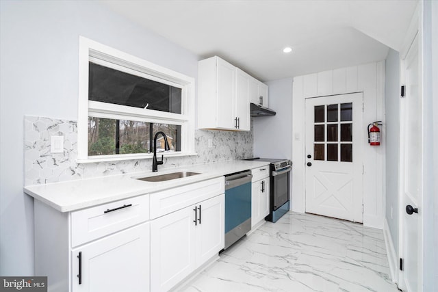 kitchen featuring white cabinets, decorative backsplash, stainless steel appliances, and sink