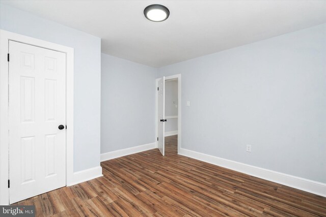 unfurnished room with dark hardwood / wood-style flooring