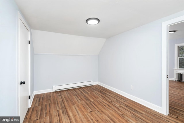 additional living space with vaulted ceiling, wood-type flooring, radiator, and a baseboard radiator