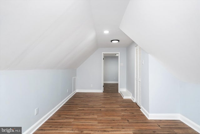 bonus room with vaulted ceiling and dark wood-type flooring