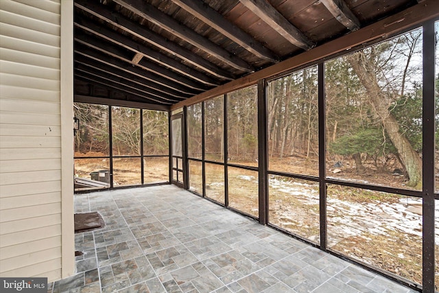 unfurnished sunroom featuring vaulted ceiling with beams and wooden ceiling