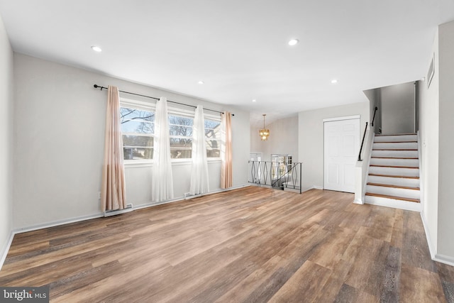 unfurnished living room featuring hardwood / wood-style flooring and a notable chandelier