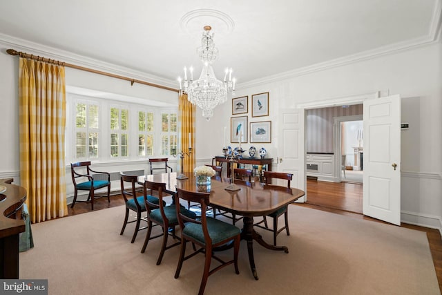 dining room with hardwood / wood-style floors, baseboard heating, ornamental molding, and a chandelier