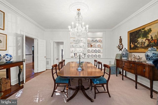 carpeted dining room with a notable chandelier, built in features, and ornamental molding