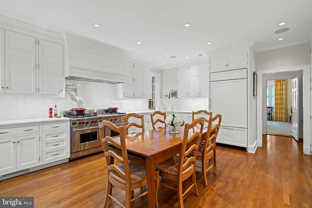 dining space featuring light wood-type flooring and ornamental molding