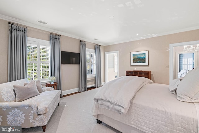 bedroom featuring ensuite bath, an inviting chandelier, crown molding, and hardwood / wood-style floors