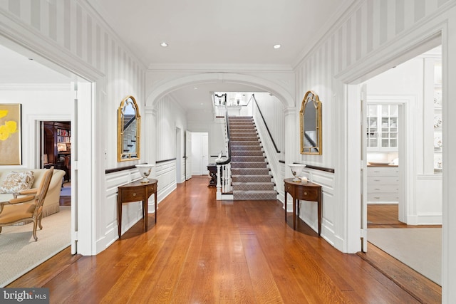 foyer with crown molding and hardwood / wood-style floors