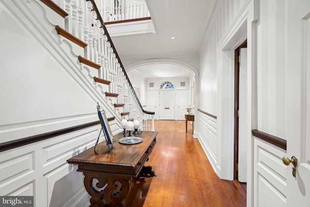 hallway with ornamental molding and wood-type flooring