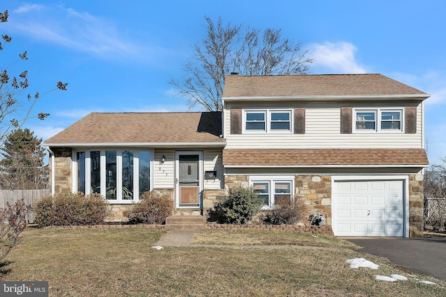 split level home with a garage and a front lawn