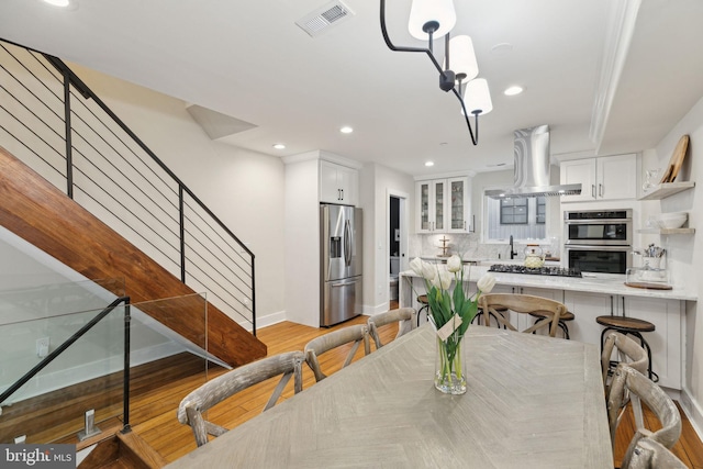 dining area featuring recessed lighting, visible vents, baseboards, stairs, and light wood-style floors